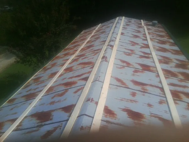 Rusted metal roof panels with new wood purlins before replacement — Storm Damage Roof Repair in Wrightsville Beach by Roofing Brothers