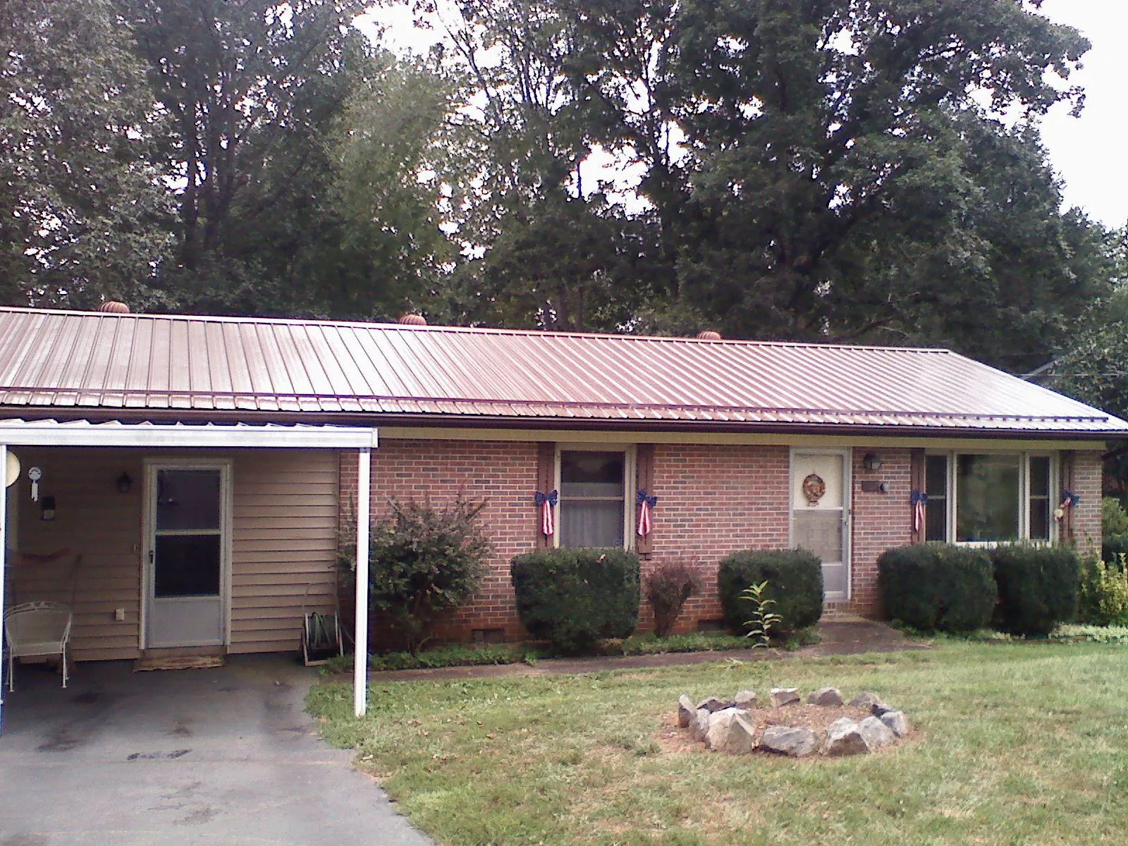Bronze metal roof and carport on a brick ranch home — Roof Repair work by our crew in Wrightsville Beach