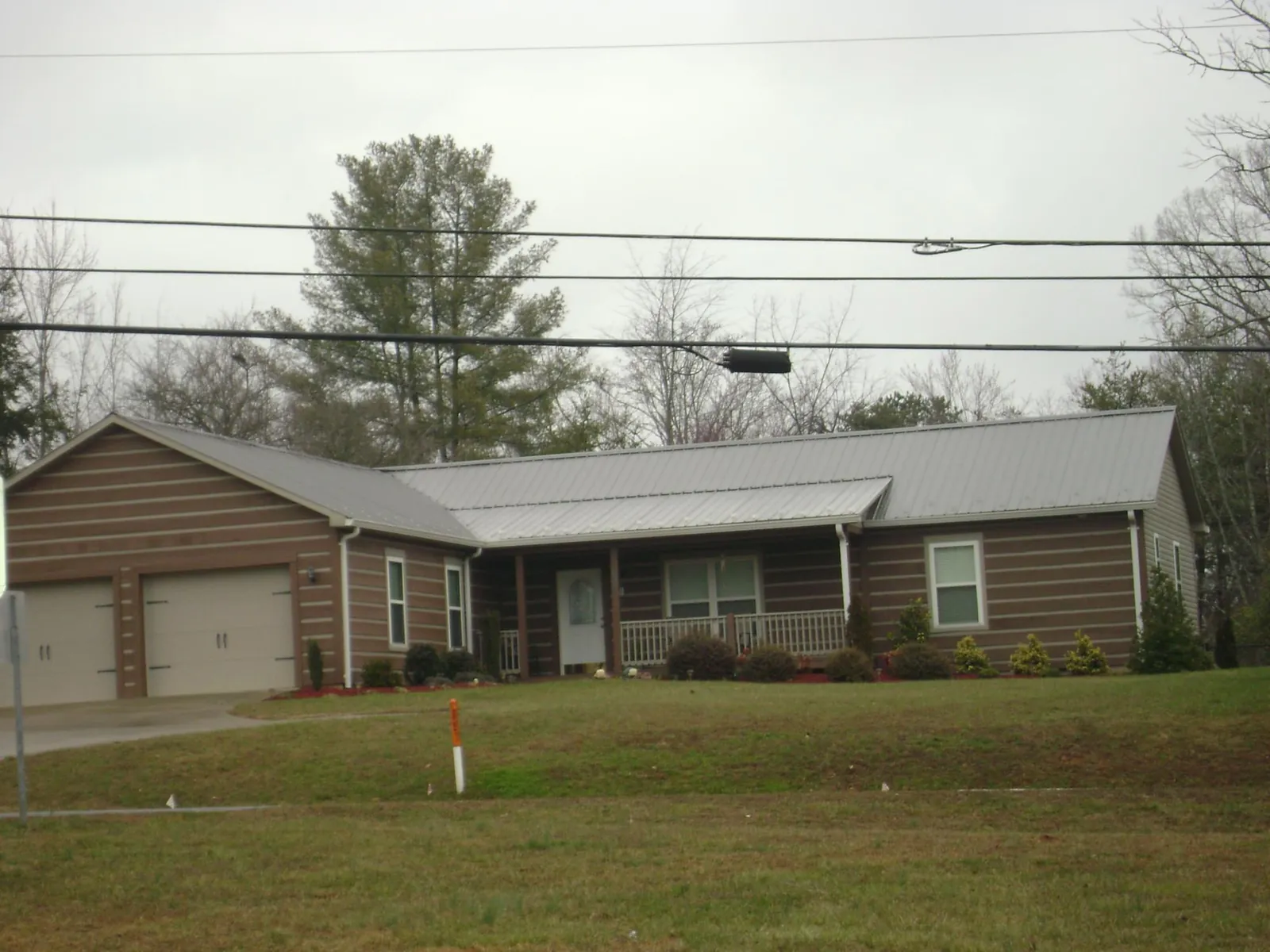 Gray metal roof on a log sided ranch home with a front porch in Wrightsville Beach